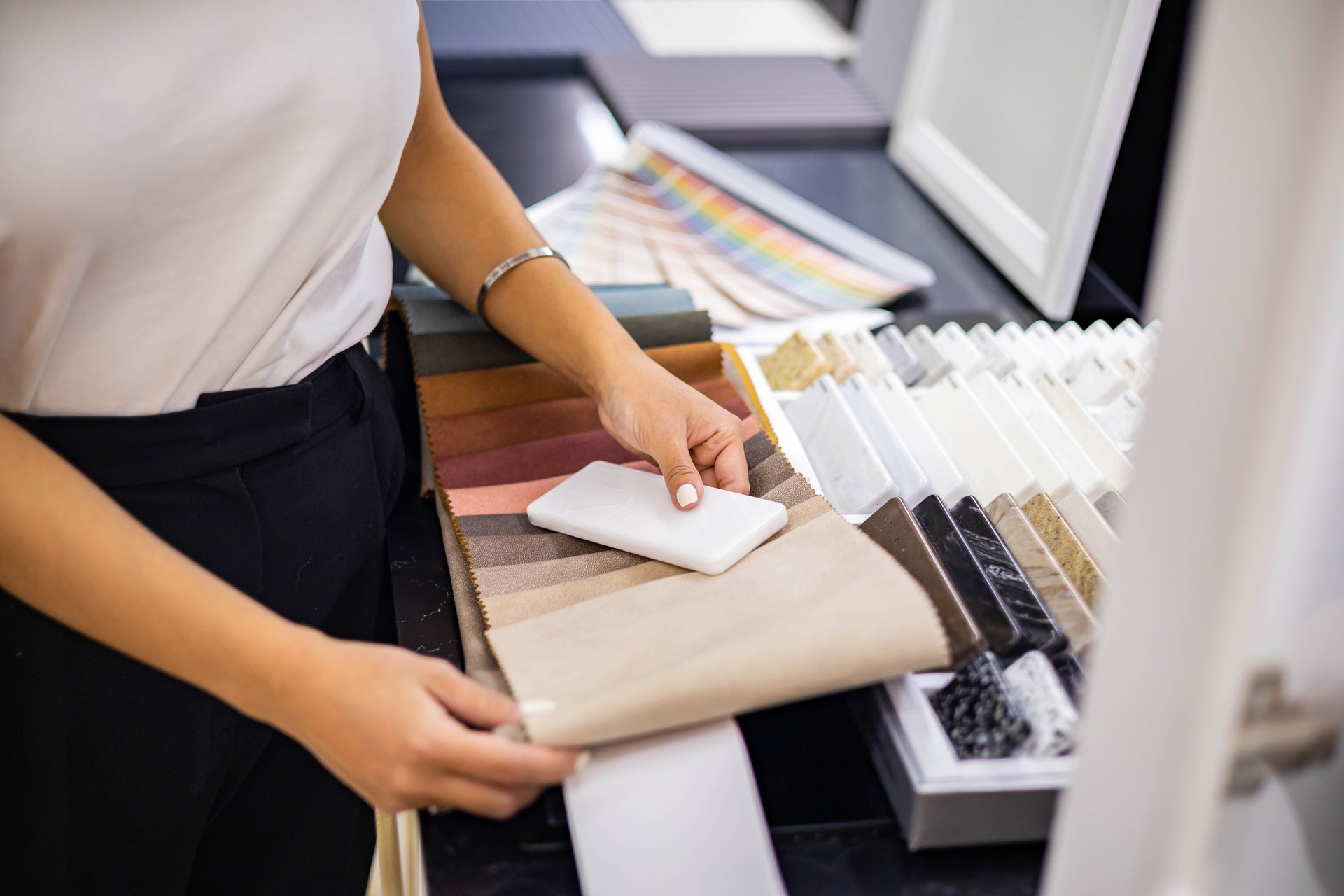 Asian woman interior designer chooses color of stone countertop for kitchen or facades
